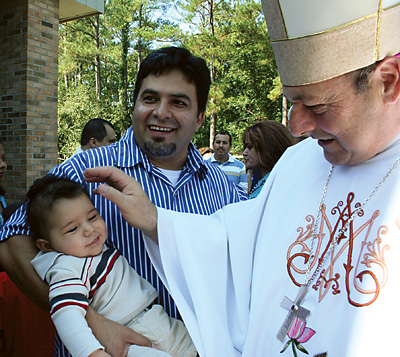 Bishop Robert E. Guglielmone blesses a baby after Mass at the annual Diocese of Charleston Hispanic Festival Oct. 3.