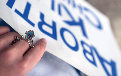 An unidentified woman holds a pro-life sign during the Respect Life Sunday annual Life Chain in Myrtle Beach Oct. 4. On her finger is a rosary ring.