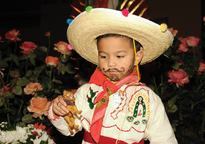 Two-year-old Luis Yahir Solano is dressed as St. Juan Diego, with an embroidered image of Our Lady of Guadalupe on his shirt, for the celebrations at St. Mary Magdalene Church in Simpsonville.