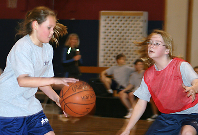 Alexis Fritz, at left, a Prince of Peace fifth-grader, makes her move against Aimee McVey, a St. Paul the Apostle sixth-grader, at a basketball game held in Taylors to celebrate Catholic Schools Week.