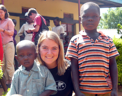 A Clemson student poses with Ugandan boys during a spring break mission trip in May 2009