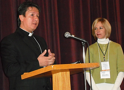 Father Teofilo Trujillo, pastor of St. Mary Magdalene Church, and Sabrina Moore, council chairwoman, speak at a stewardship conference on March 6.