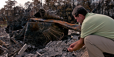 Joseph Gosiewski sifts through the rubble of his former home in North Myrtle Beach in this file photo from April 2009. The original was destroyed in the devastating wildfires that burned 20,000 acres in Horry County last year. Gosiewski’s new home is built on the same site.