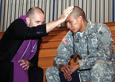 Father David Reinhart, a new chaplain in the U.S. Air Force and a priest from the Diocese of Toledo, gives a soldier absolution after hearing his confession before Mass at Fort Jackson in Columbia on July 31. (Miscellany/Christina Lee Knauss)