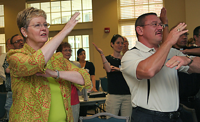 Roberta Lamson-Motter and Deacon Peter M. Cassamento, both of Our Lady Star of the Sea Church in North Myrtle Beach, practice hand gestures of a song to remember the basic principles of the Rite of Christian Initiation at St. Peter Church in Columbia Aug. 28. (Miscellany/Christina Lee Knauss)