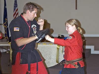 Caity Hicks, 11, and Nick Dreiling from a local martial arts center demonstrate defensive moves during Immaculate Conception Church’s safety fair held Aug. 22. (Miscellany/Amy Wise Taylor)