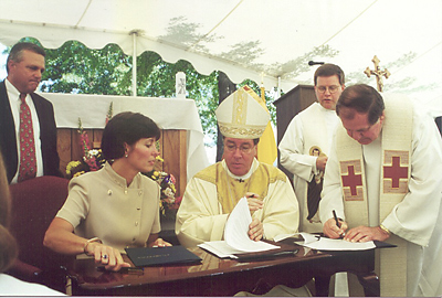 Margaret Ann Moon, board of trustees chair at St. Joseph’s Catholic School, and Bishop Robert J. Baker, formerly of the Diocese of Charleston, signed documents signifying the recognition of the school by the diocese in 2000. (Photo Provided)