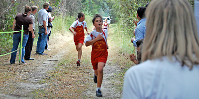 (Photo Provided) Noah Kimbrell and Brooks Wilson, two members of St. Peter School’s cross-country team, pound through the woods on the way to an undefeated season.