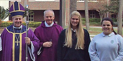 (Photo Provided) Bishop Robert E. Guglielmone and Father Richard B. Tomlinson are pictured with Bishop England students Elizabeth Works and Caitlin Paul Dec. 10.
